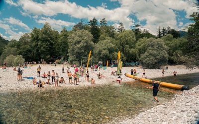 Tekači na Soča Outdoor Festivalu prečkajo mrzlo reko Tolminko v cilj.